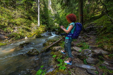 Naklejka premium Woman photographing Ponor creek Romania