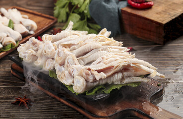 Fresh Raw Chicken Feet on Wooden Board with Vegetables and Spices for Asian Cooking
