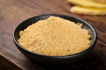 Fresh Ground Ginger Powder Spice in Bowl on Wooden Table for Cooking and BBQ Seasoning