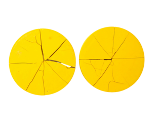 Two vibrant yellow circular discs, each cracked into radiating segments, exhibiting a similar pattern of fracturing.  The cracks are thin and dark, contrasting the bright yellow surface