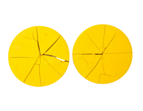Two vibrant yellow circular discs, each cracked into radiating segments, exhibiting a similar pattern of fracturing.  The cracks are thin and dark, contrasting the bright yellow surface