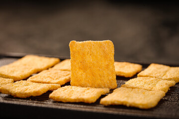 Handmade Golden Millet Crackers on Dark Slate Surface - Healthy Artisan Snack Food Photography