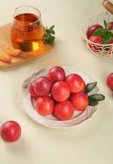 Fresh Chilean Jumbo Plums on Decorative Plate with Herbal Tea - Healthy Organic Stone Fruit Display