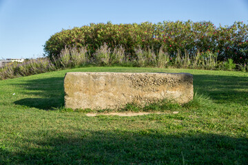 A large stone sits in a grassy field