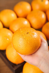 Fresh Orange in Hand with Water Drops - Natural Citrus Fruit Sweetness and Freshness