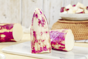 Fresh Purple Skinned Yam Slices Cut on White Marble Kitchen Counter