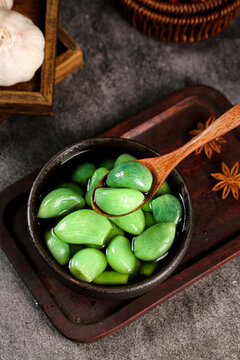 Fresh Green Olives in Wooden Bowl with Spices and Garlic on Rustic Kitchen Table