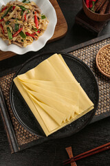 Fresh Handmade Tofu Sheets with Asian Stir-Fry Vegetables and Soybeans on Wooden Table