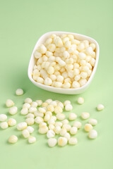 Fresh Peeled Corn Kernels in White Bowl on Green Background for Healthy Cooking and Breakfast