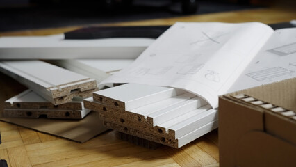 Pile of just unpacked elements of a new chest of drawers ready for assembling