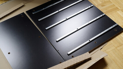 Pile of just unpacked elements of a new chest of drawers ready for assembling