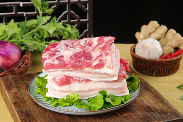 Fresh Raw Pork Belly Thick Cut Slices with Fat Marbling on Wooden Cutting Board Kitchen Setup