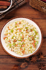Fresh Corn Pearl Stir Fry with Ham and Vegetables on Rustic Wooden Table