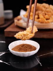 Crispy Fried Pork Cutlet with Chopsticks and Seasoning Bowl - Traditional Asian Food Preparation