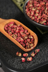 Sichuan Hanyuan Dahongpao Peppercorns Chinese Spice Seasoning in Wooden Spoon on Dark Background