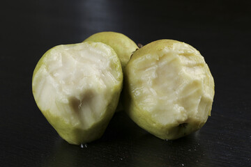 Fresh Guangxi Guava Fruit Cut in Half Showing White Cream Flesh Heart Shape on Black Background
