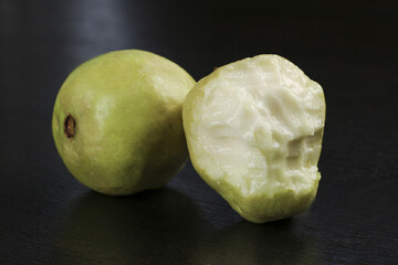 Fresh Guava Fruit with Soft Cream Flesh and Heart-Shaped Pulp on Dark Wood Surface
