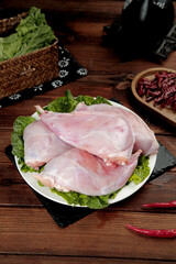 Fresh Raw Rabbit Meat Forelegs with Sichuan Cooking Ingredients on Wooden Kitchen Table