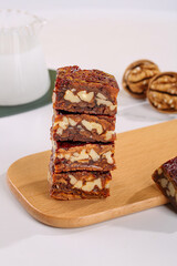 Traditional Xinjiang Walnut Jujube Date Bars Stacked on Wooden Cutting Board with Milk