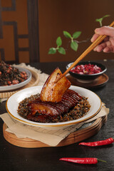 Traditional Braised Pork Belly with Dried Plum Vegetables and Chopsticks on Bamboo Steamer