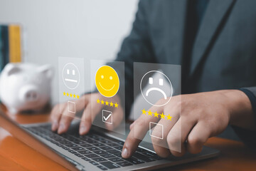 Businessman using laptop with virtual feedback icons showing customer satisfaction rating from...
