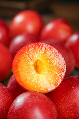 Fresh Red Plums Cut in Half Showing Juicy Yellow Flesh and Stone Fruit Detail