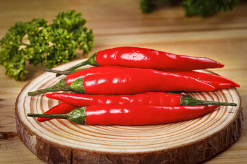 Fresh Red Chili Peppers on Wooden Board with Herbs Kitchen Background