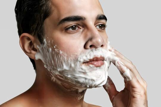young man smears shaving gel concept on your face un joven se unta gel de afeitar en la cara un jeune homme &eacute;tale du gel &agrave; raser sur votre visage giovane uomo spalma gel da barba sul viso traş tras