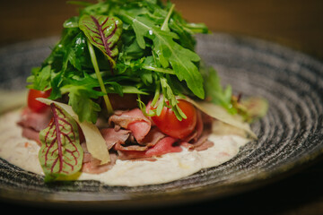 Vitello tonnato with cherry tomatoes and fresh greens