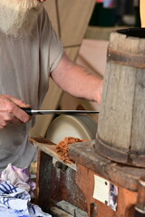 Messerschleifer. Detail eines Mannes der ein Messer an einer rotierenden Steinscheibe schleift