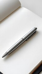 Naklejka premium Stock photo of silver pen on blank notebook page for writing journaling and creativity