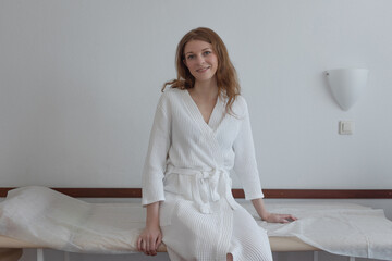 Joyful patient in white medical robe seated in modern detox facility
