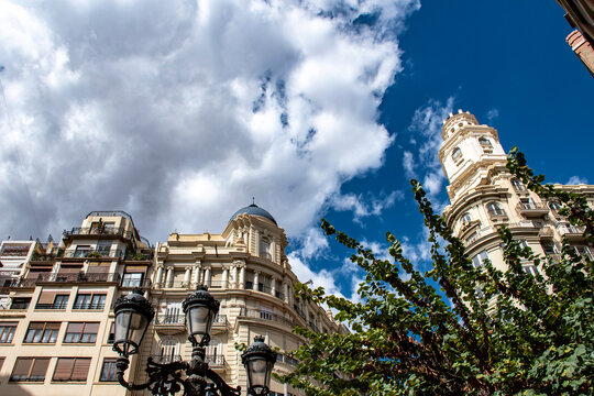 Plano contrapicado de edificios hist&oacute;ricos en Valencia, con un cielo azul y nubes blancas