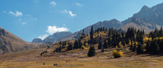 Majestic Kazakh landscape: snow-capped peaks, forested hills, and golden steppes in one frame.