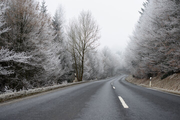 black ice - a street in the evening with the warning sign