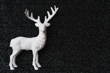 Decorative white deer figure on glossy black background with space for text.