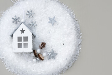 Top view of a wooden house on artificial snow on a gray background.