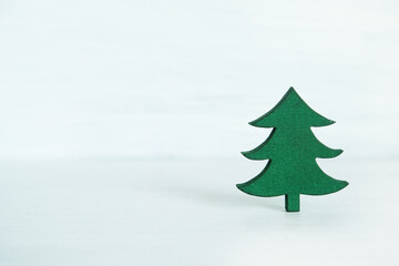 wooden miniature Christmas tree placed against a rustic gray wooden background.