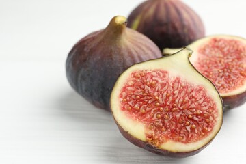 Whole and cut figs on white table, closeup