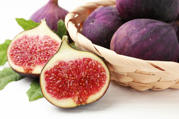 Whole and cut figs on white table, closeup
