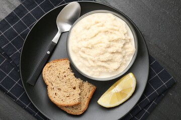 Tasty horseradish sauce served on black table, top view