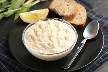 Tasty horseradish sauce served on black table, closeup