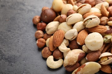 Mix of different nuts on grey table, closeup. Space for text