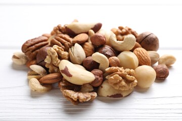 Mix of different nuts on white wooden table, closeup