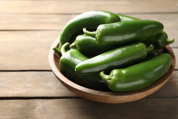 Fresh jalapeno peppers on wooden table, closeup