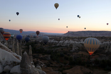 Flying hot air balloons rise in sunrise Cappadocia.
