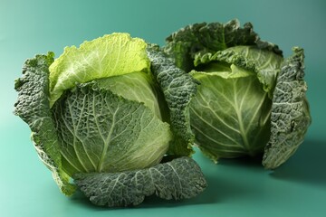 Fresh Savoy cabbages on teal background, closeup © New Africa