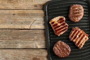 Delicious grilled beef meat on wooden table, top view. Space for text