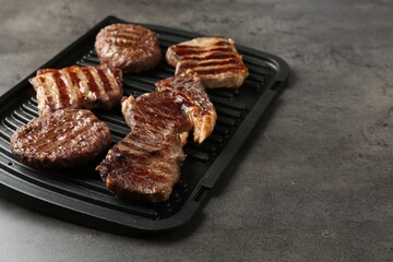 Delicious grilled beef meat on grey table, closeup. Space for text