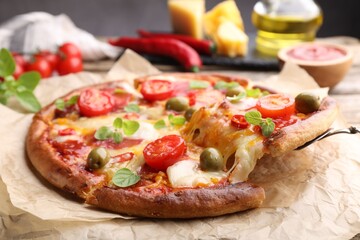 Taking piece of delicious pizza with cheese, tomatoes and olives at table, closeup